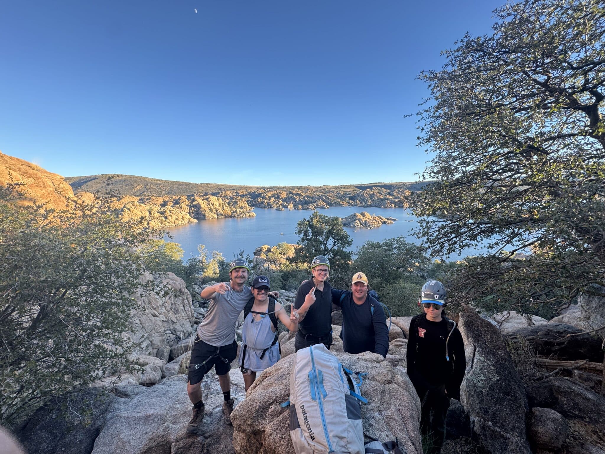 A group posing in front of a lake while on a hike.